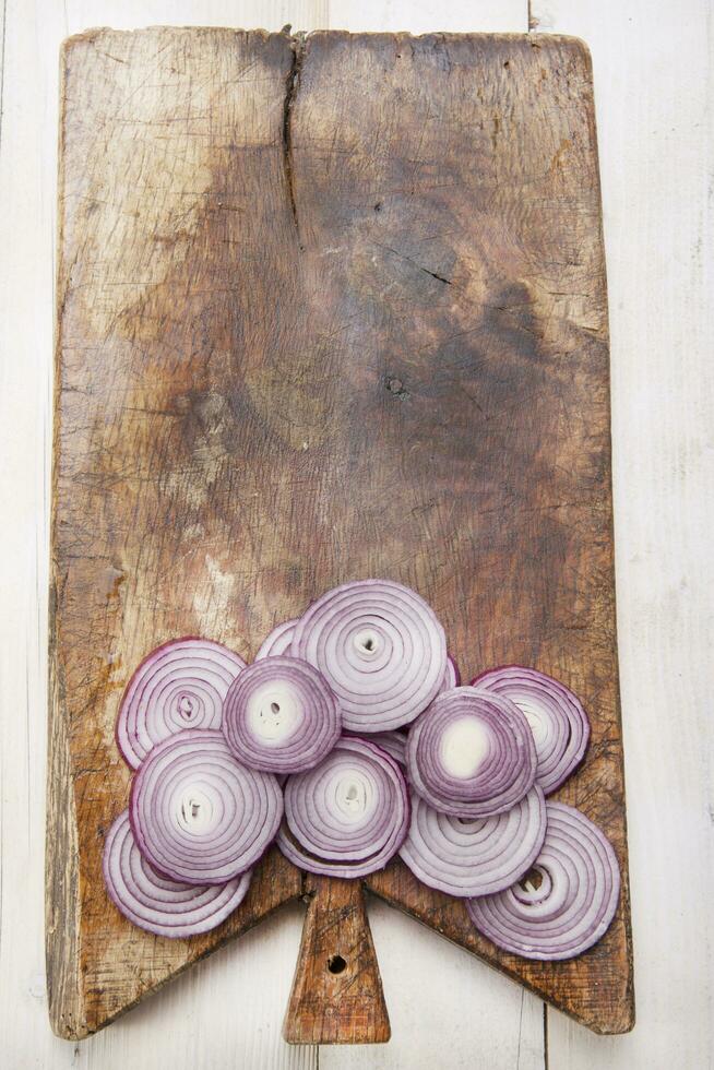 a knife and a bunch of onions on a cutting board photo