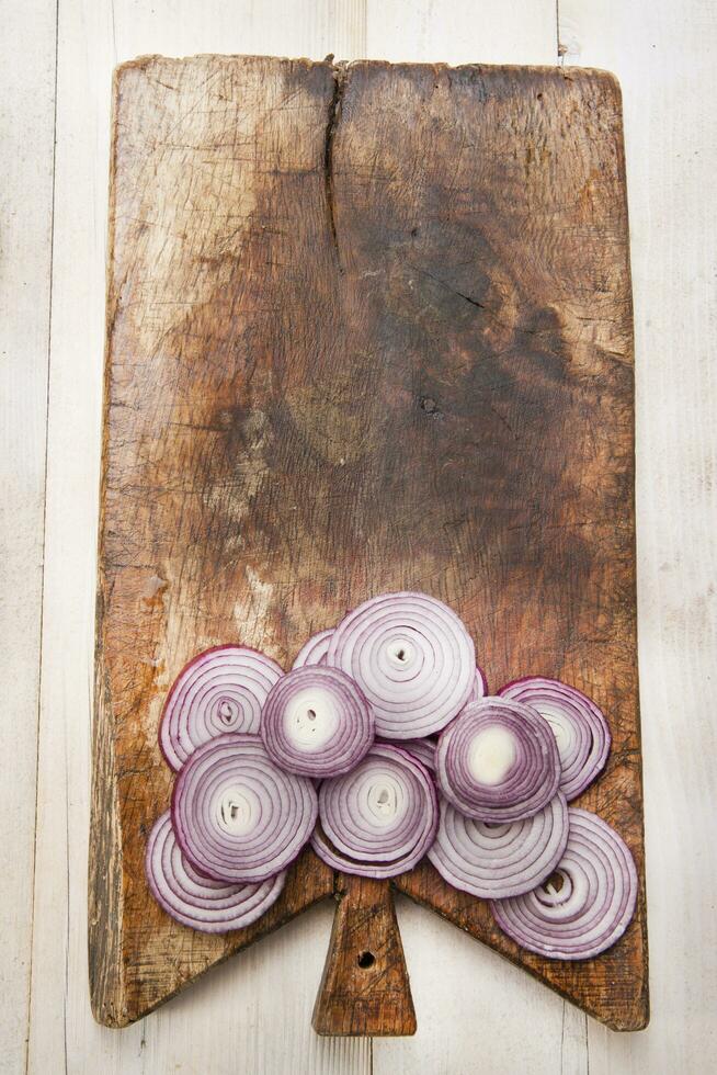 a knife and a bunch of onions on a cutting board photo