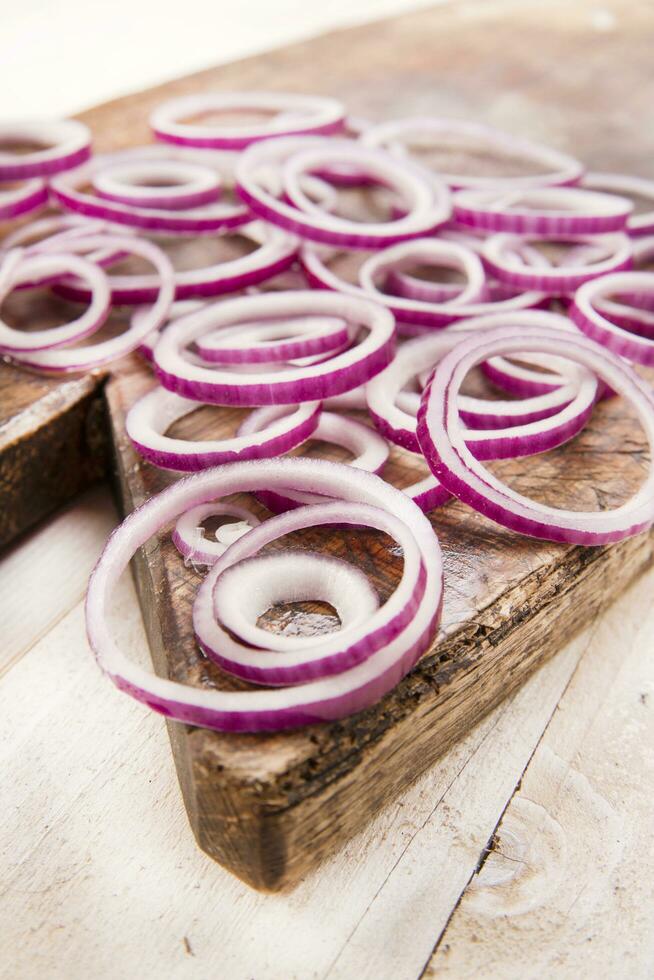 a knife and a bunch of onions on a cutting board photo