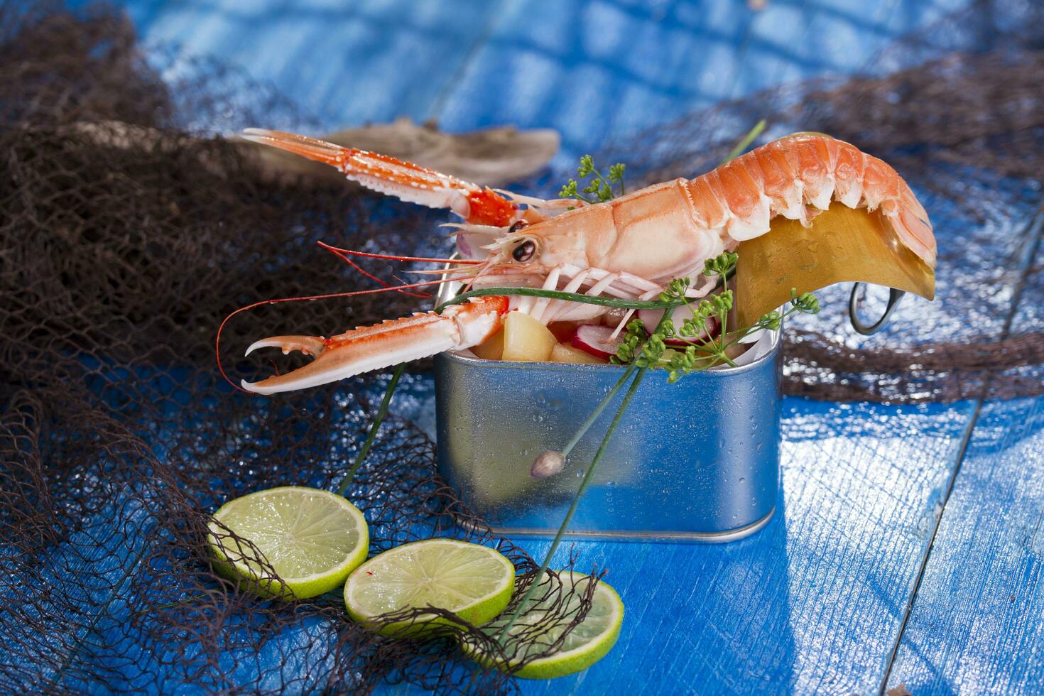 a shrimp in a container with a lime on a blue table photo