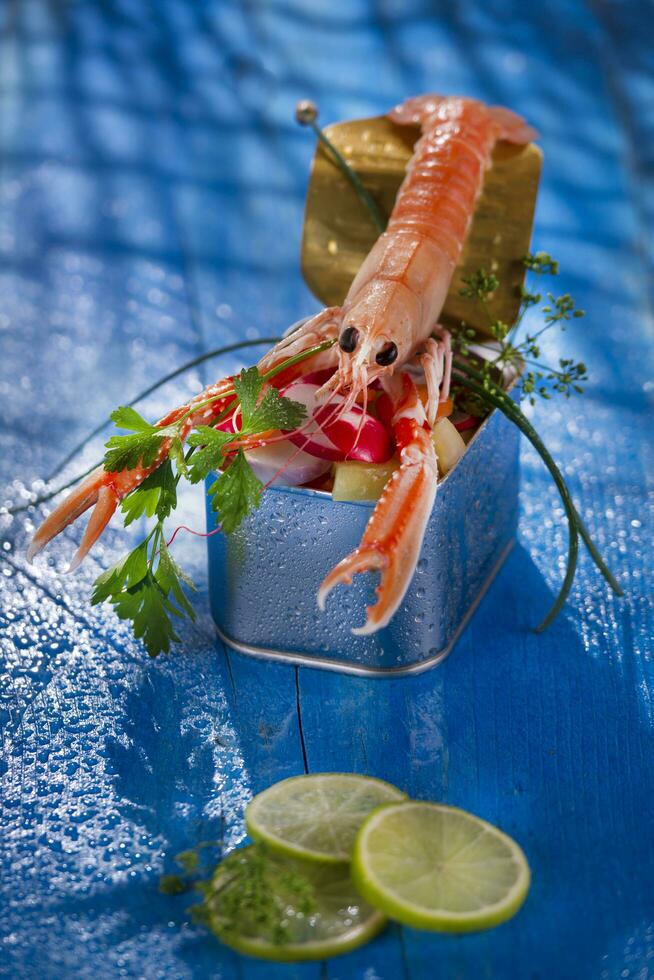 a shrimp in a container with a lime on a blue table photo