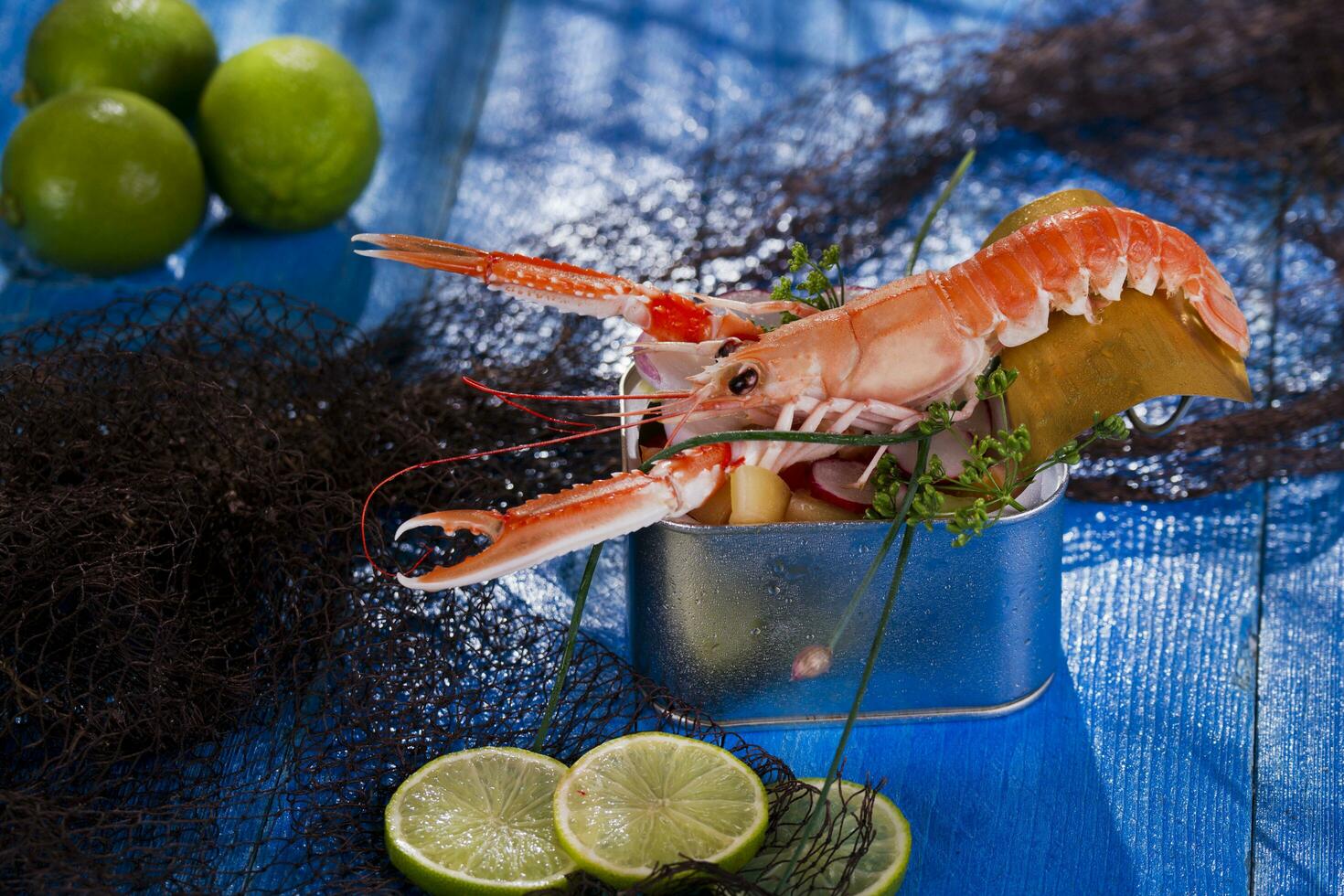 un camarón en un envase con un Lima en un azul mesa foto