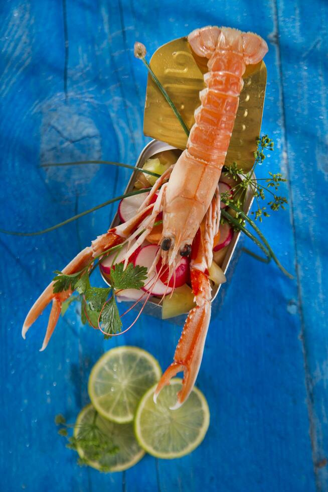 a shrimp in a container with a lime on a blue table photo