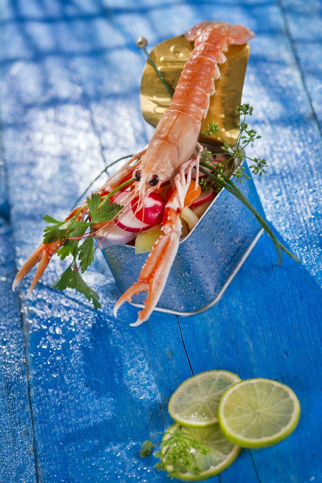 a shrimp in a container with a lime on a blue table photo