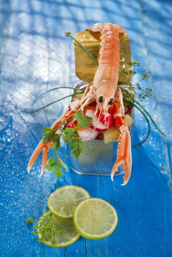 a shrimp in a container with a lime on a blue table photo