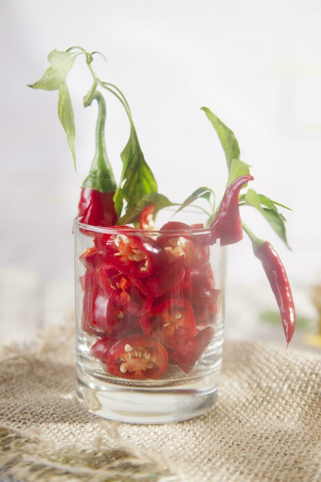 a glass filled with red peppers and a straw photo