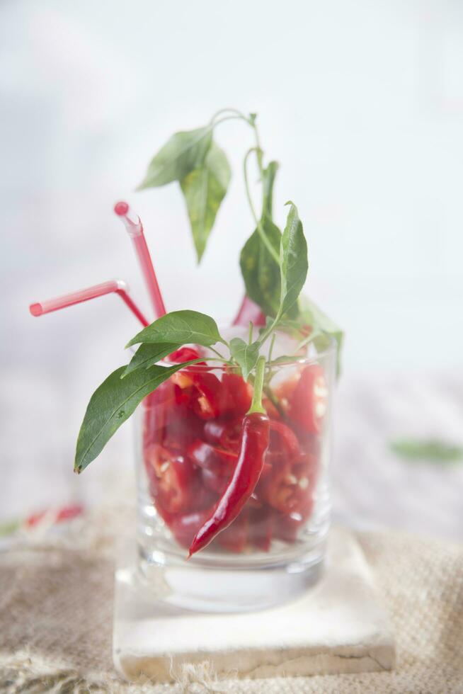 a glass filled with red peppers and a straw photo