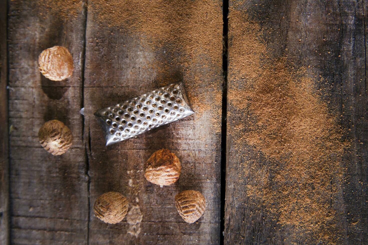 a grater with nuts on a wooden surface photo