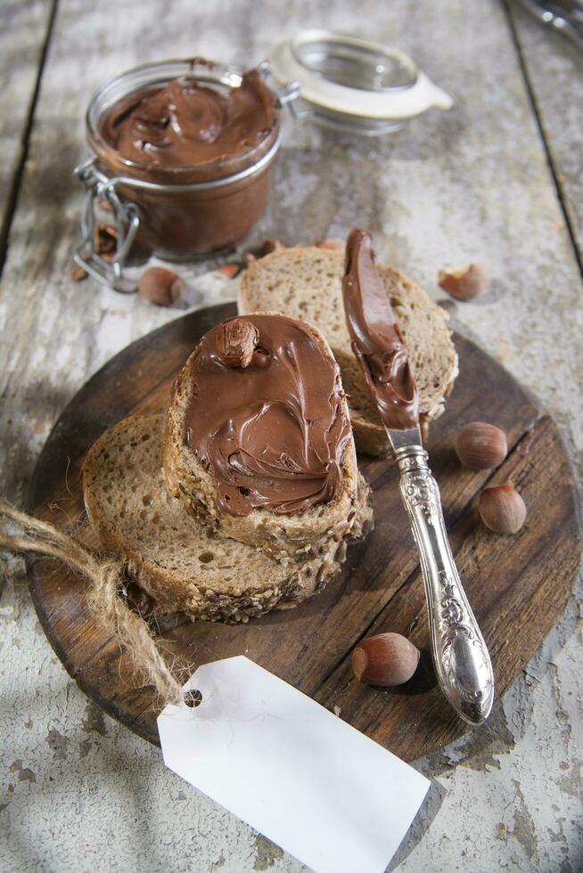 a plate with a piece of bread and a jar of nut butter photo