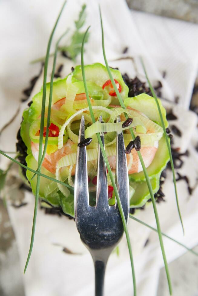 Tower of black and white rice with shrimp and zucchini photo