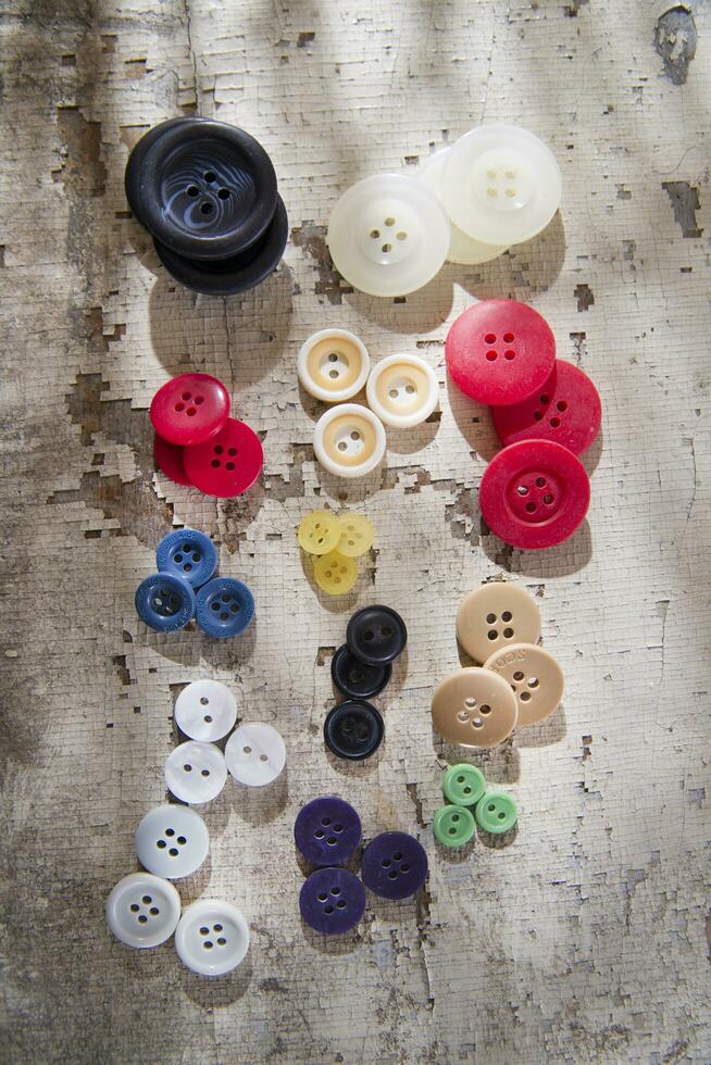 sewing supplies and buttons arranged on a white surface photo