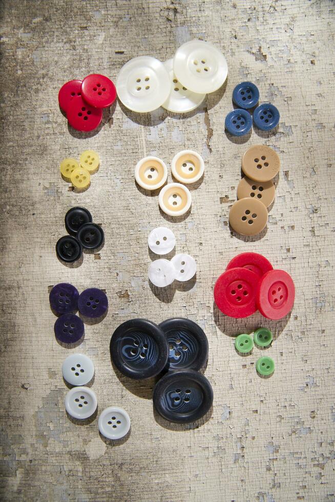 sewing supplies and buttons arranged on a white surface photo