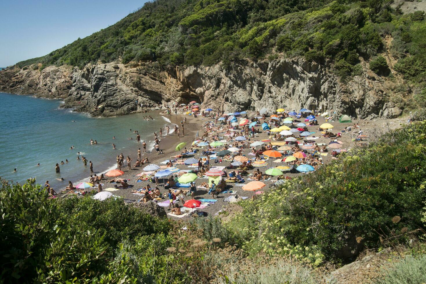 a sandy beach with many people photo