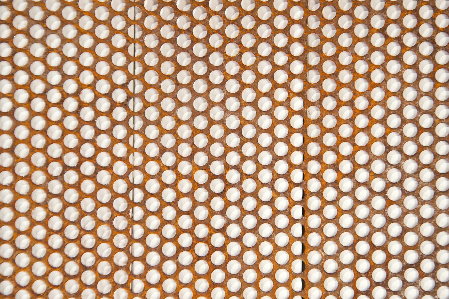 a close up of a metal mesh with holes photo