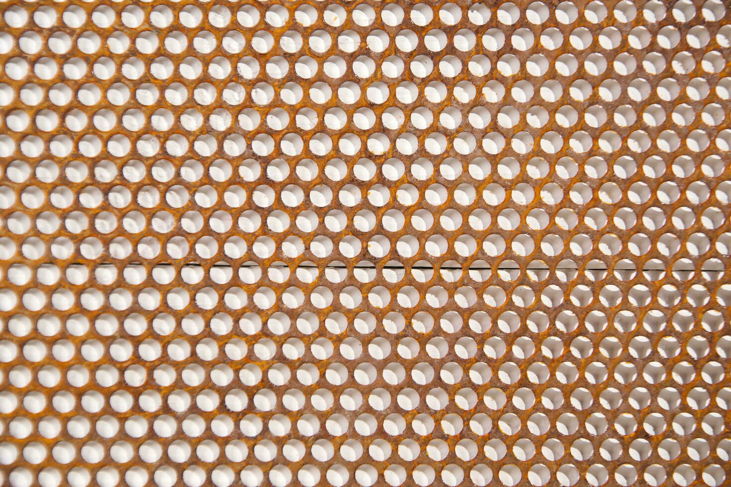 a close up of a metal mesh with holes photo