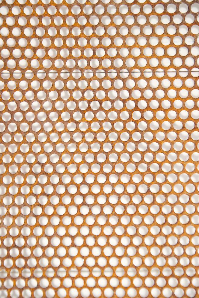 a close up of a metal mesh with holes photo