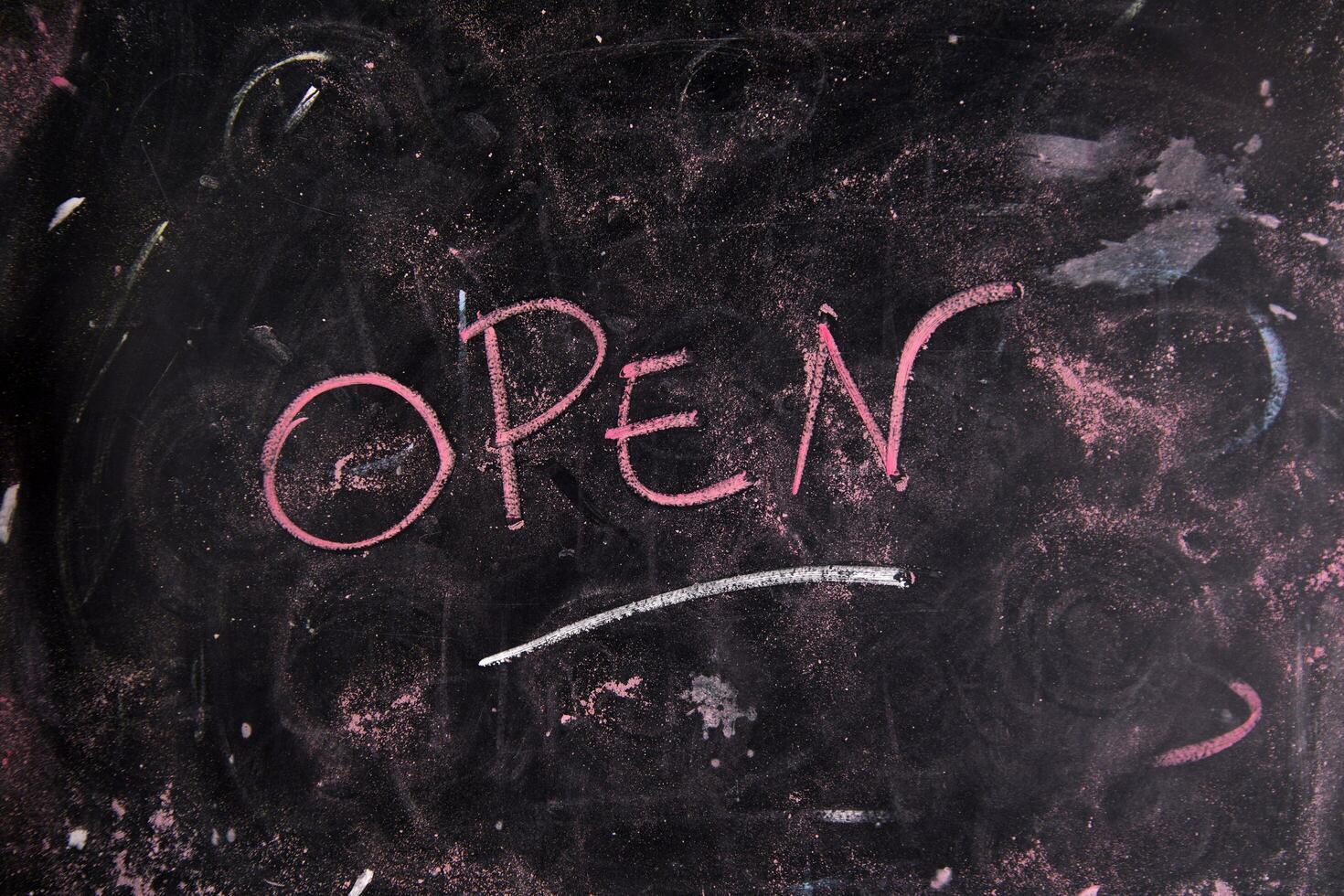 open written on a blackboard with a pink marker photo