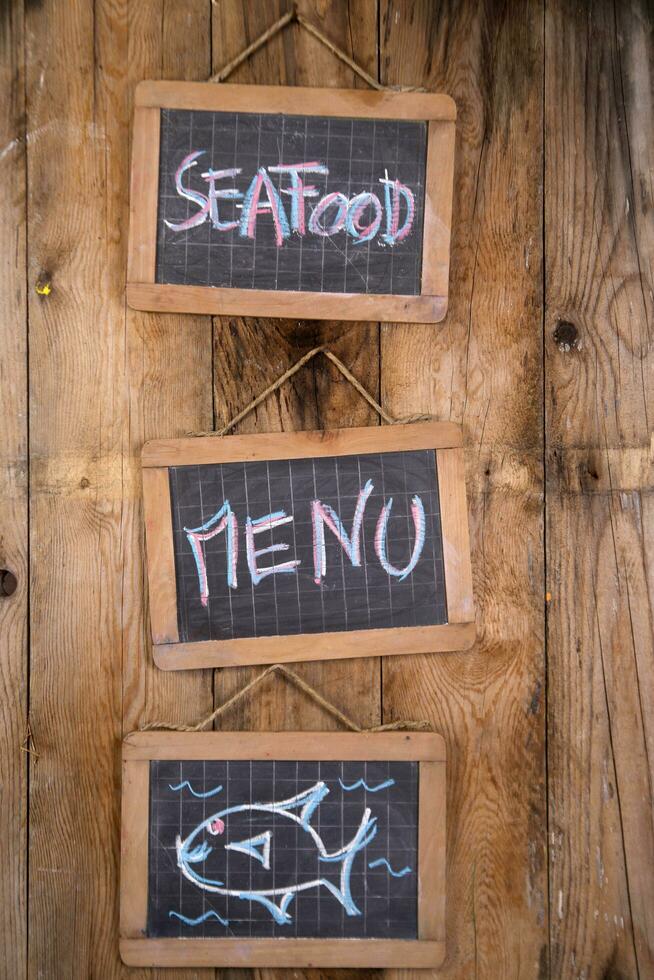 three blackboards with the words seafood menu and fish on them photo