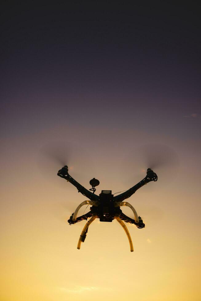 Quadrocopter in flight at sunset photo