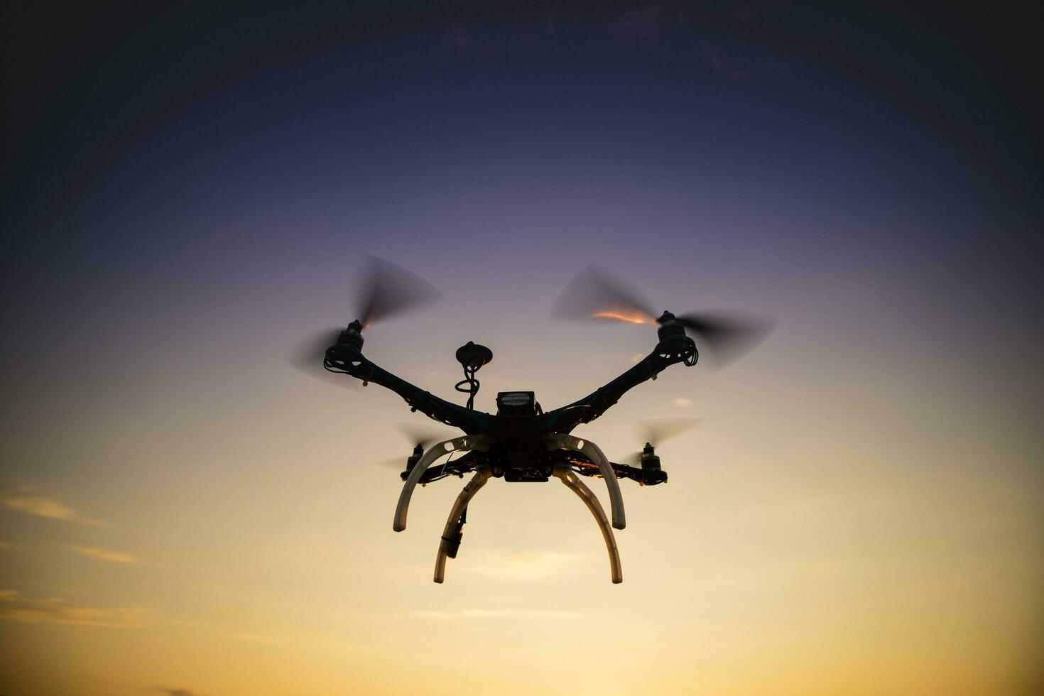 Quadrocopter in flight at sunset photo