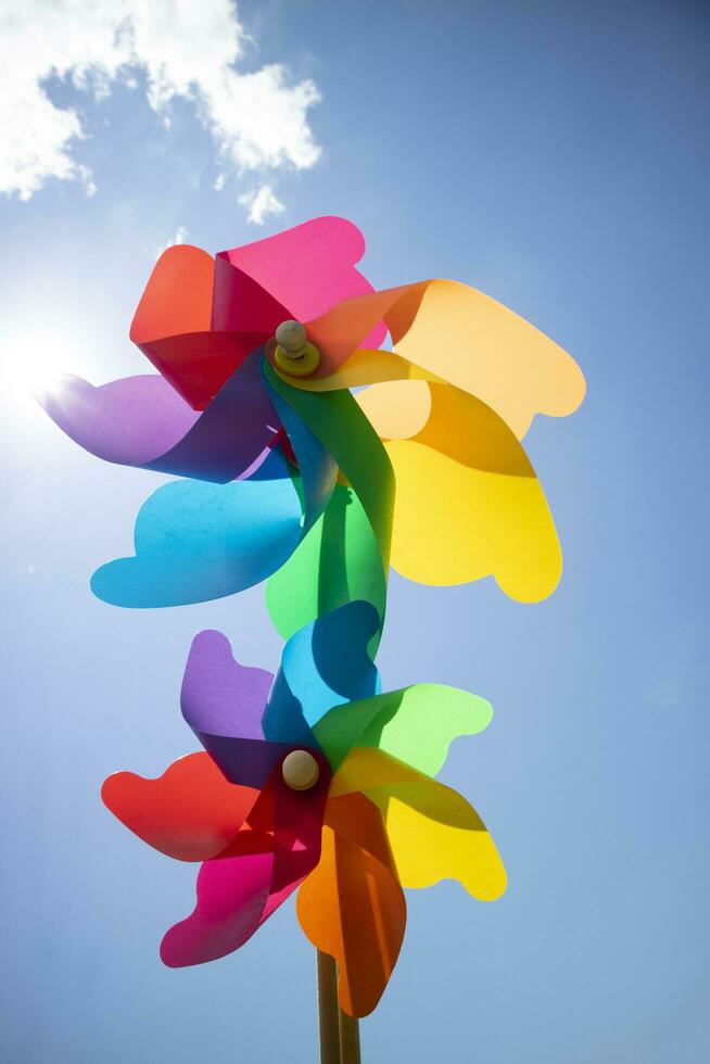 Multicolored pinwheels in the blue sky photo