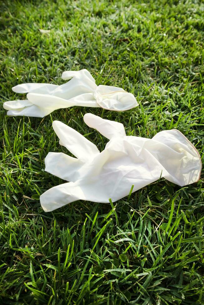 Disposable anti Coronavirus gloves thrown on the ground photo