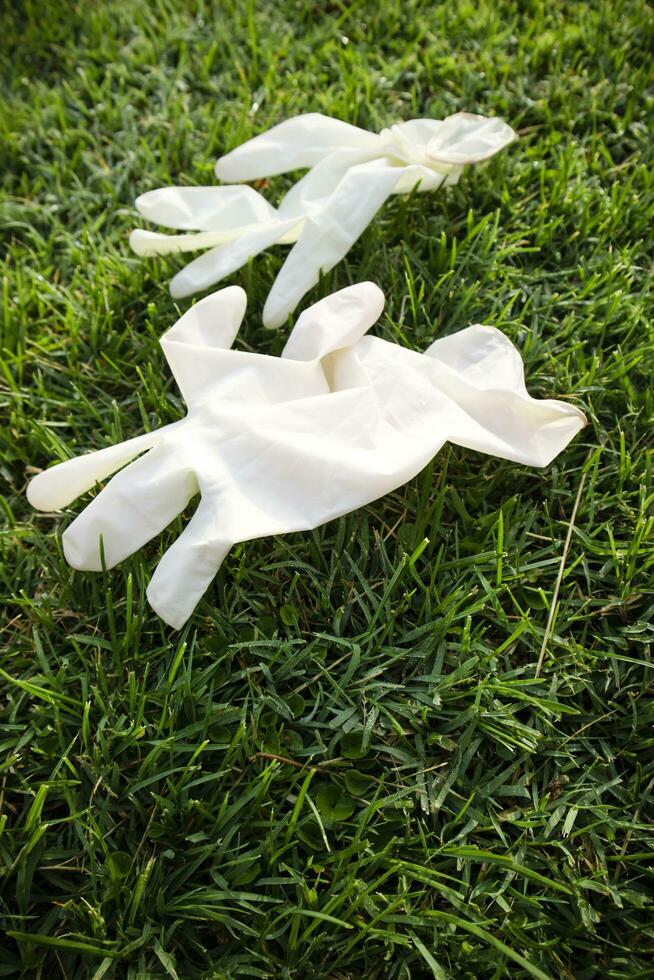 Disposable anti Coronavirus gloves thrown on the ground photo