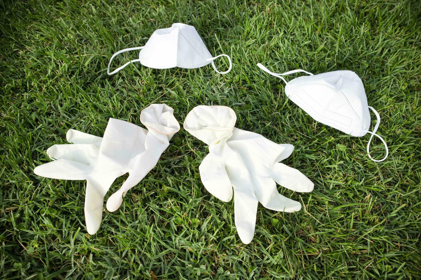 Anti Covid-19 masks thrown on the ground creating pollution. photo