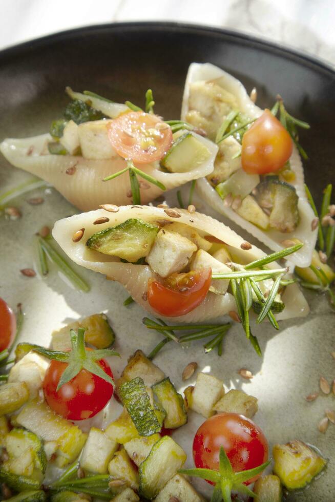 Vegan pasta shell iced with tofu and courgette sauce and olive oil photo