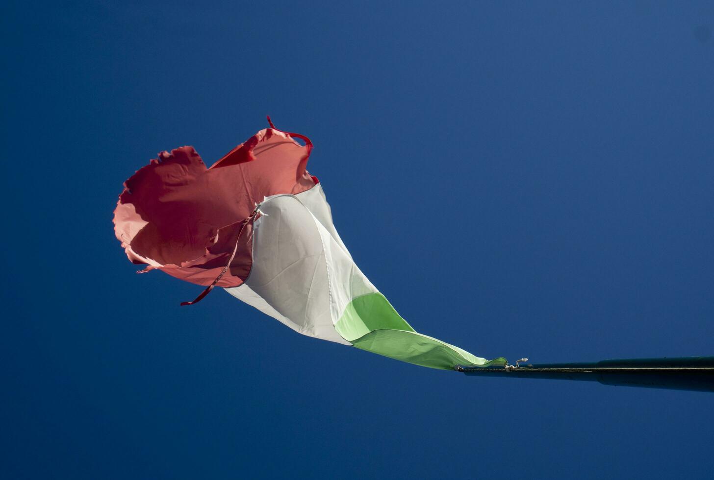 The Italian flag worn by the wind photo