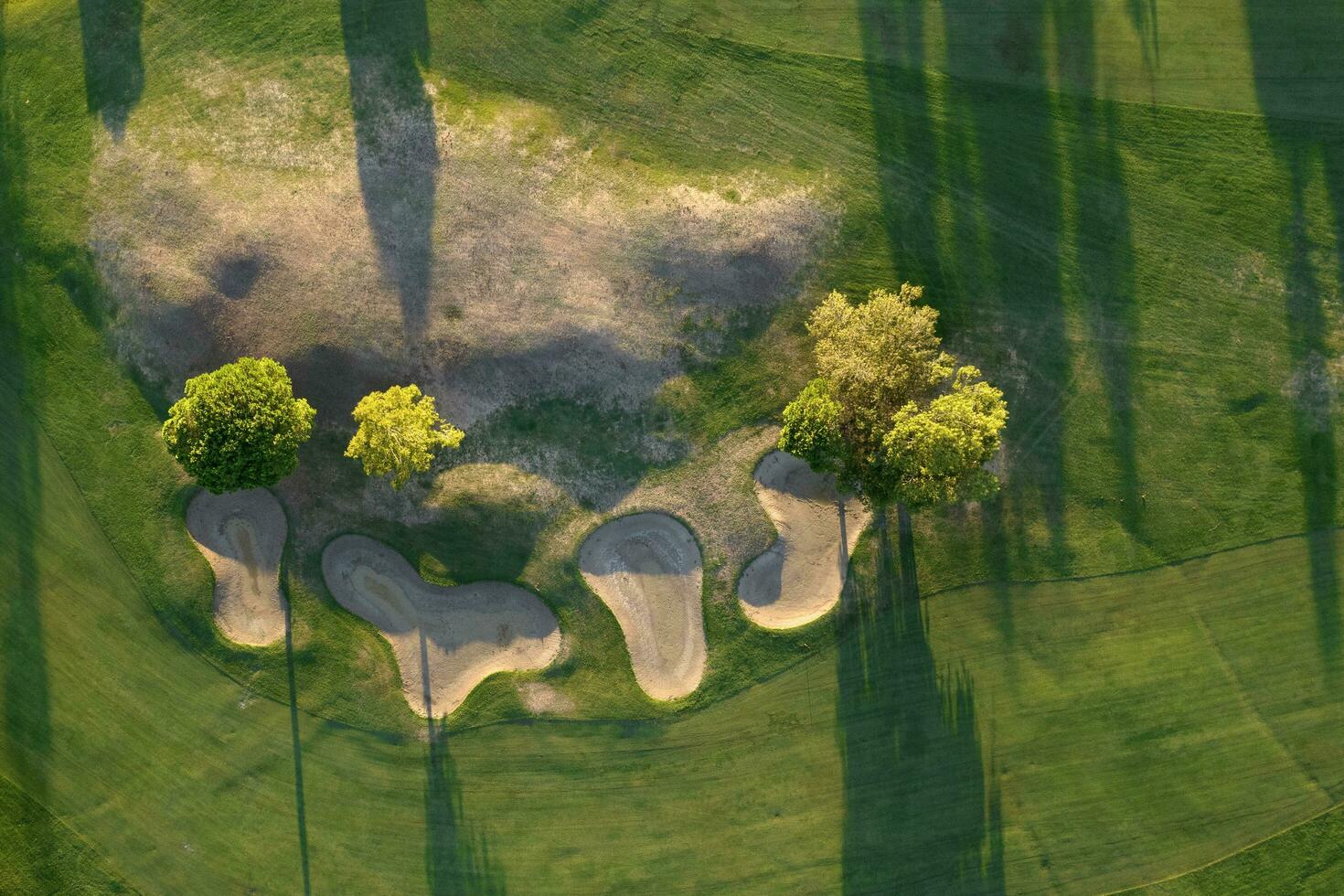 Aerial view of a green golf course at sunset photo