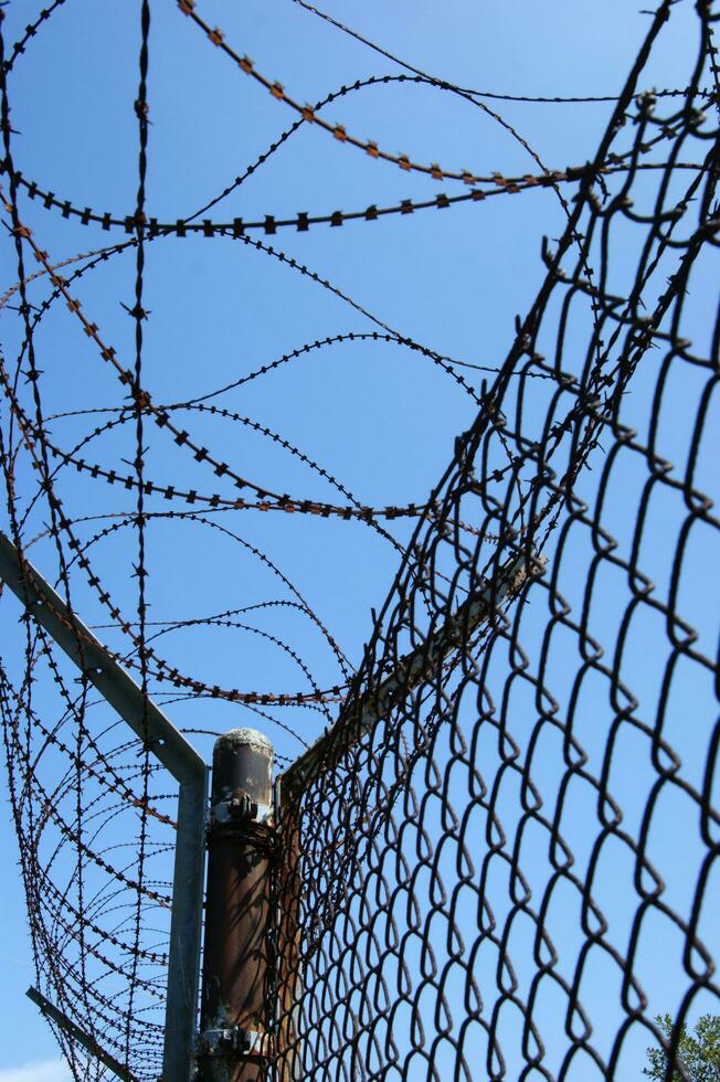 a barbed wire fence with a blue sky in the background photo