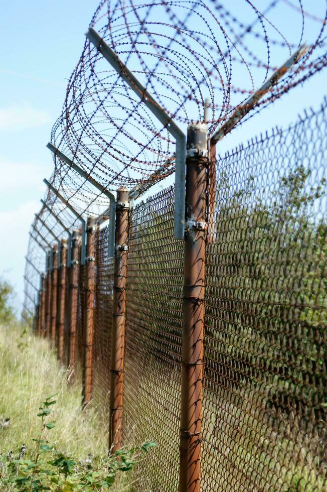a barbed wire fence with a blue sky in the background photo