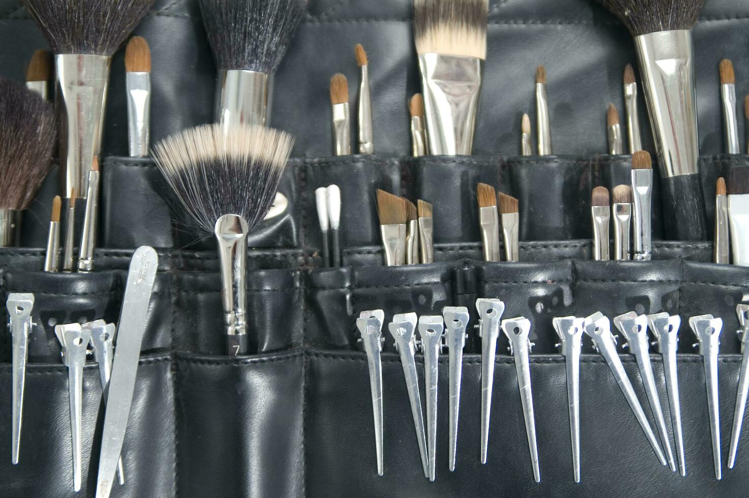 a black leather case with many brushes and other tools photo