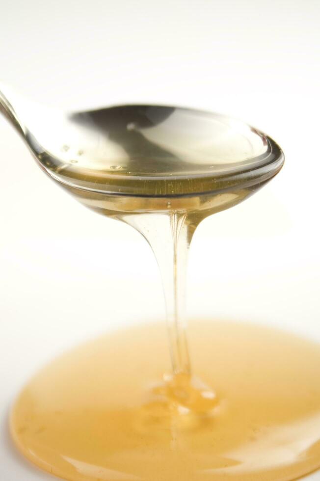 honey dripping from a wooden stick photo