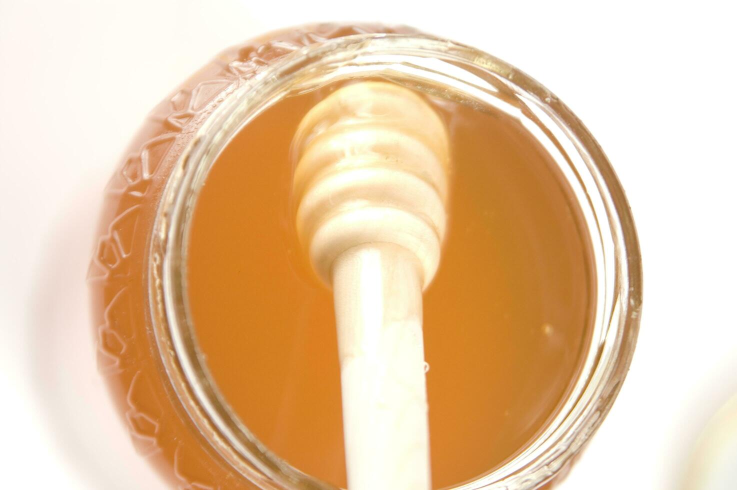 honey dripping from a wooden stick photo