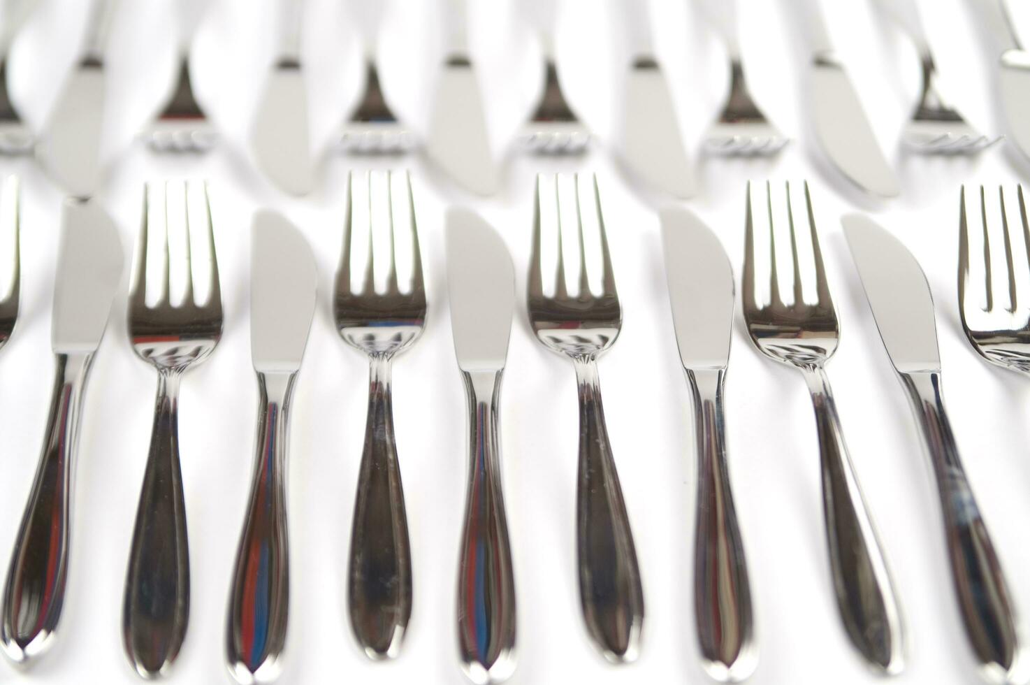 many forks and knives are arranged in a pile photo