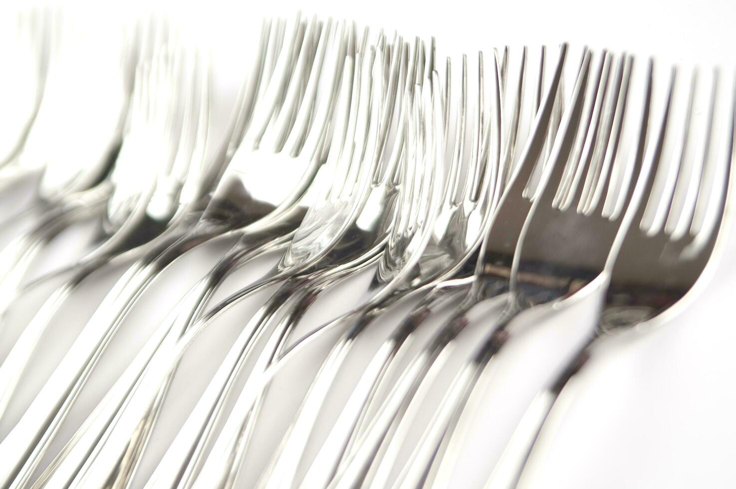 many forks and knives are arranged in a pile photo