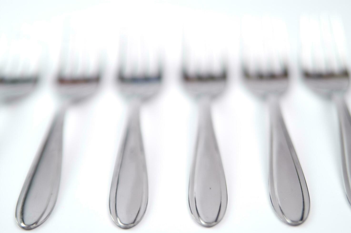 many forks and knives are arranged in a pile photo