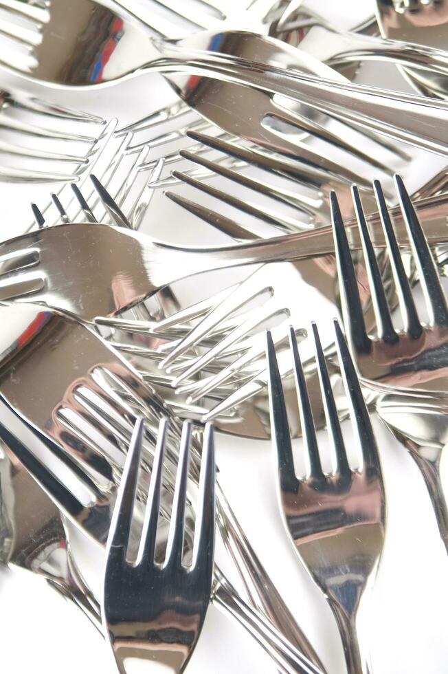 many forks and knives are arranged in a pile photo