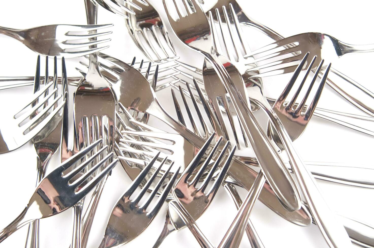 many forks and knives are arranged in a pile photo