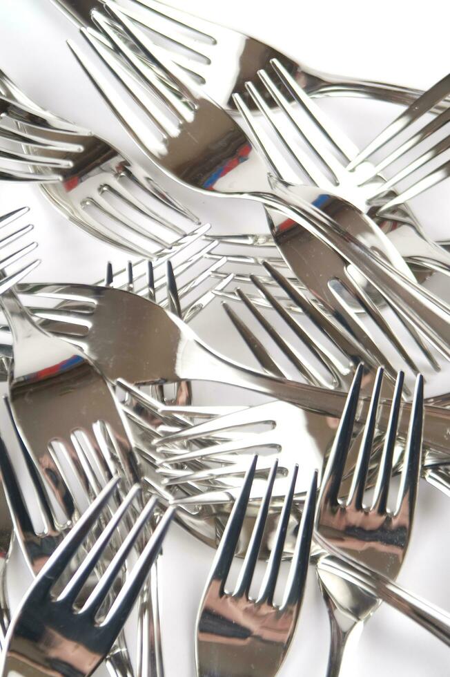many forks and knives are arranged in a pile photo