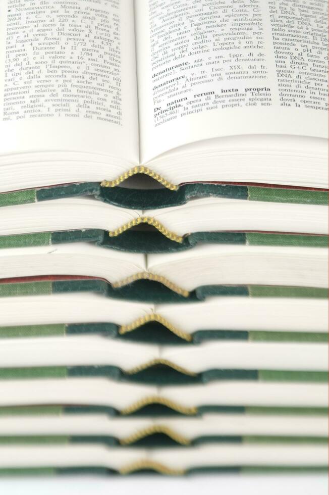 a stack of open books with green and gold trim photo