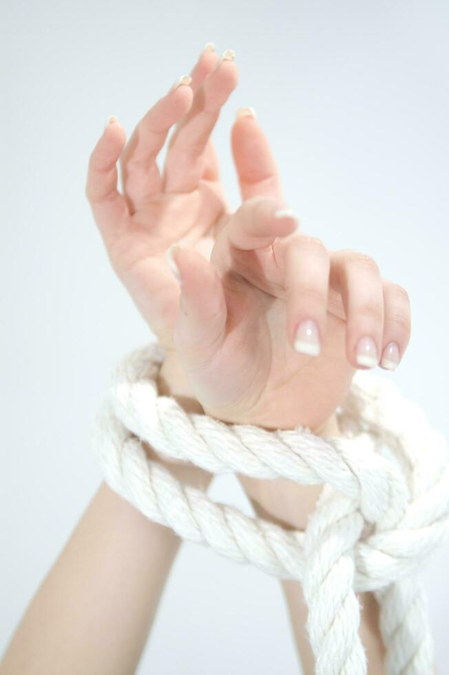 a woman's hands are tied to a rope photo