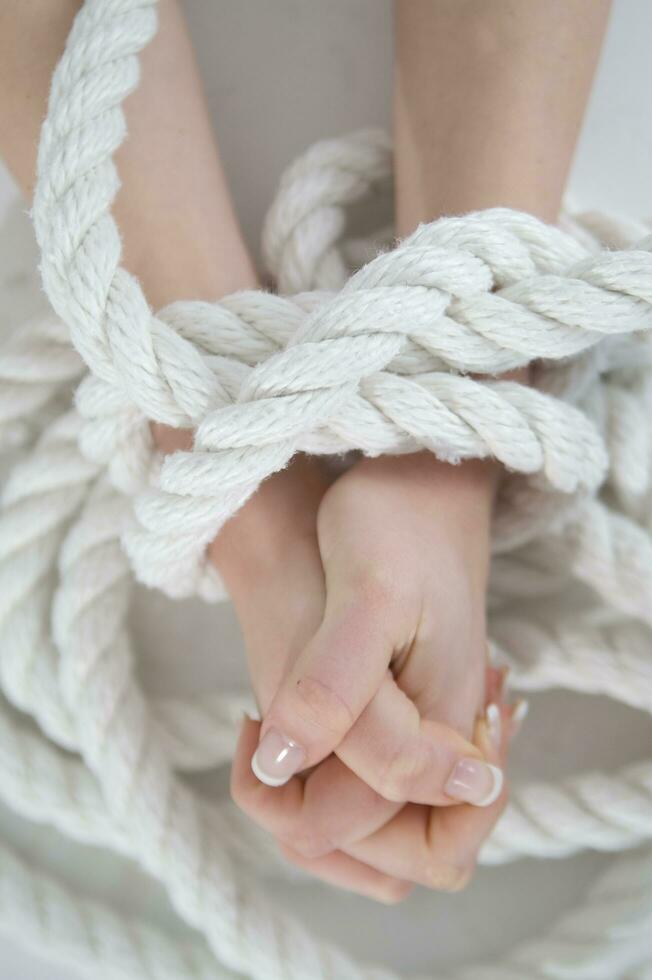a woman's hands are tied to a rope photo