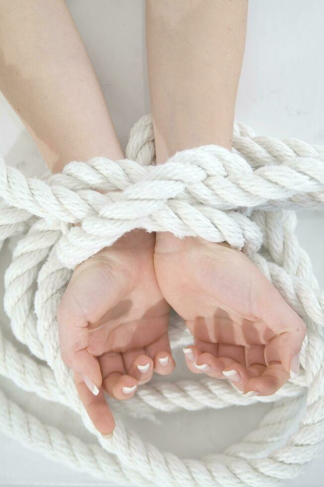 a woman's hands are tied to a rope photo