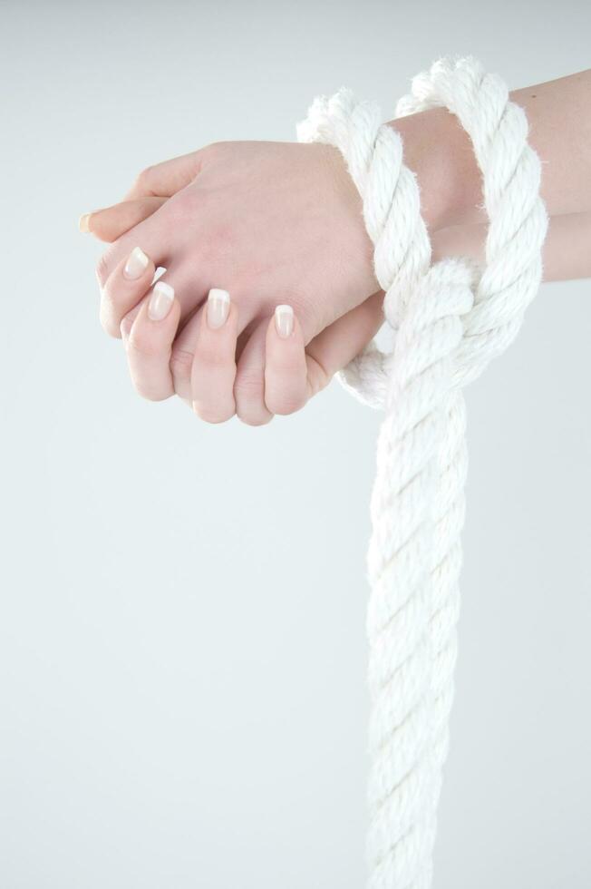 a woman's hands are tied to a rope photo
