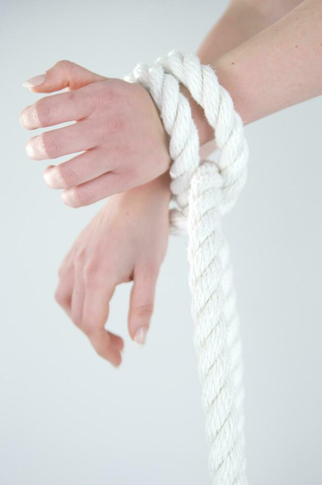 a woman's hands are tied to a rope photo