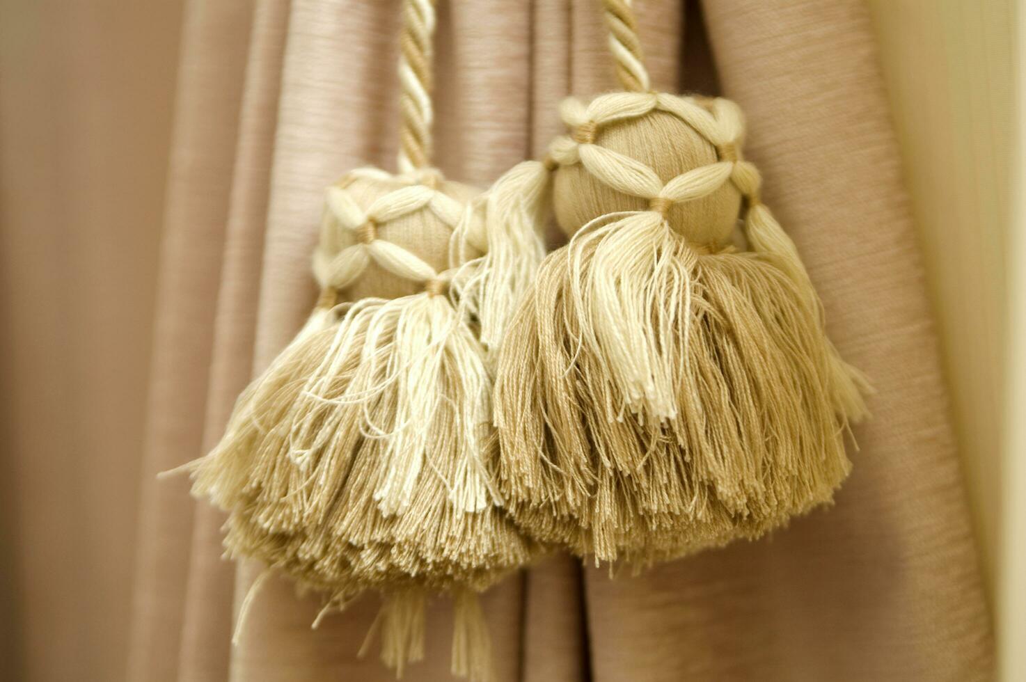 two tassels hanging from a curtain rod photo