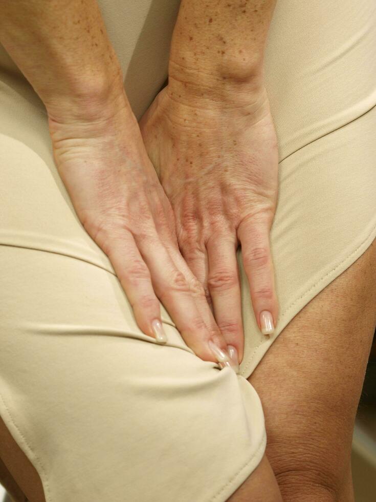 a woman is holding her stomach photo